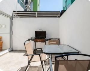a table and chairs in a room with a laptop at El descanso del guerrero in Barra Vieja