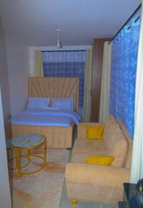 a bedroom with a bed and a couch and a table at Eden Homes in Nairobi
