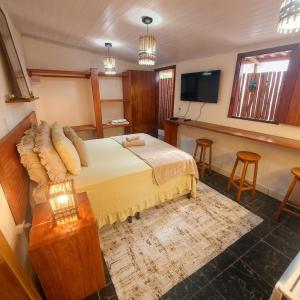 a hotel room with a bed and a television at Residência Thomas in Itacaré