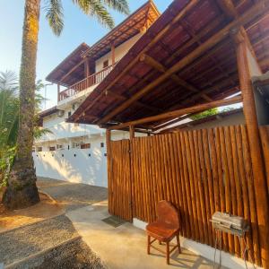 a wooden fence with a chair next to a building at Residência Thomas in Itacaré