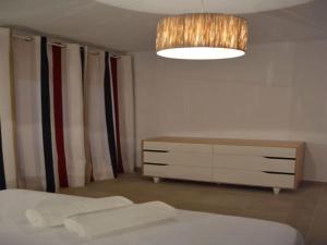 ein Schlafzimmer mit einem Bett, einer Kommode und einer Lampe in der Unterkunft Livingtarifa Apartamento Anhelo in Tarifa