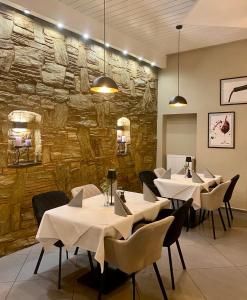 a restaurant with tables and chairs and a stone wall at Pension DaVinci in Schwetzingen