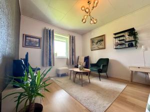 a living room with a table and a chair at Appartment with garden and a big bathroom in Malvik