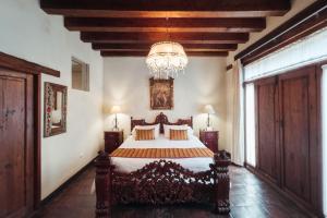 a bedroom with a bed and a chandelier at Mansion de los Sueños in Pátzcuaro