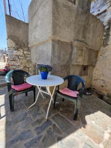 two chairs and a table and a table and chairs at Sidirounta Traditional Home 2 in Chios