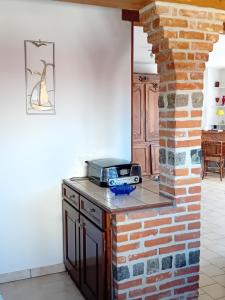 a kitchen with a brick wall and a toaster on a counter at oiseau bleu in Dieppe