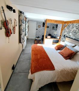 a bedroom with a bed and aviolinet on the wall at le patio de la Cavée " havre de paix" in Verderonne