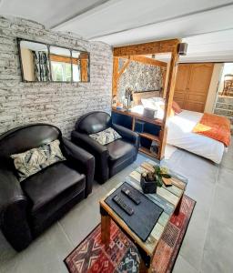 a living room with a couch and a bed at le patio de la Cavée " havre de paix" in Verderonne +24 photos