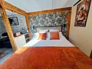 a bedroom with a bed with orange pillows at le patio de la Cavée " havre de paix" in Verderonne