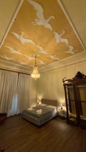 a bedroom with a bed with birds painted on the ceiling at Villa Luisetta Palmi in Palmi +65 photos