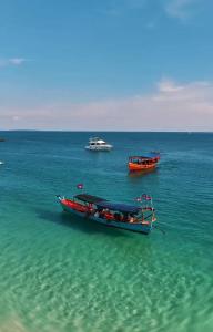 two boats sitting in the water in the ocean at Home Escape Resort in Kaôh Rŭng (3)