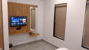 a hospital room with a tv and two windows at Hotel Dwarkesh in Dwarka
