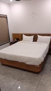 a large bed with white sheets and pillows on it at Hotel Dwarkesh in Dwarka +6 photos