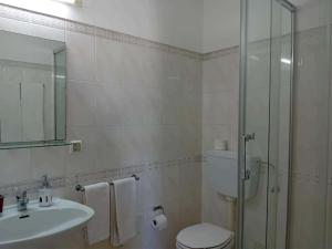 a bathroom with a toilet and a sink and a shower at Alojamento Mareta in Sagres +43 photos
