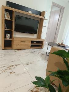 a living room with a television and a table at Cloud9 Apartment in Kavála