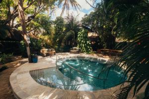 a swimming pool in a yard with trees at Kitecabana Pousada in Cumbuco +12 photos