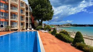a hotel swimming pool with a view of the ocean at Bellevue Beachfront Paradise in Ravda
