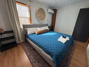 a bedroom with a bed with a blue comforter at Pet-Friendly Near Zion & Hot Tub in Downtown Kanab in Kanab