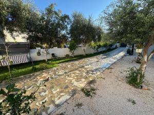 a cobblestone street with trees and a white fence at Rent Room Albano in Vlorë