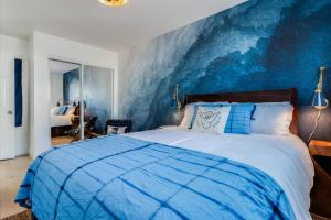 a bedroom with a large bed with a blue wall at Bella Blu in Avila Beach