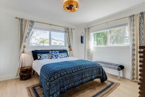 a bedroom with a bed and two windows at Bella Blu in Avila Beach