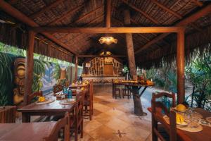 a restaurant with wooden tables and chairs in a room at Kitecabana Pousada in Cumbuco
