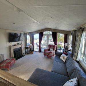 a living room with a blue couch and a fireplace at Bracken Lodge in Bucks Mills