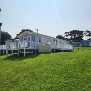 a large house with a deck on a grass field at Bracken Lodge in Bucks Mills
