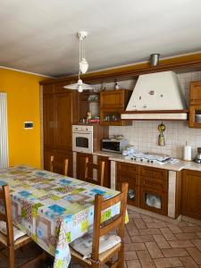a kitchen with a table and a stove top oven at La Cà di Carol Apartment in Andorno Micca +10 photos