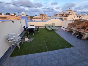 a patio with a table and chairs and grass at Piso Delfin Playa in Moncófar
