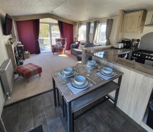 a kitchen and living room with a table with dishes on it at Bracken Lodge in Bucks Mills