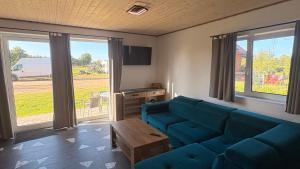 a living room with a blue couch and a table at Domki letniskowe Hamer in Łeba