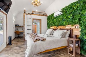 a bedroom with a bed with a green wall at Romantic Tiny Luxury Retreat w heated pool, sauna n outdoor shower in Wimberley 10 acres in Wimberley