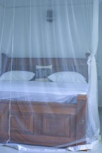 a bedroom with a wooden bed with a net at Nela House in Galle +2 photos