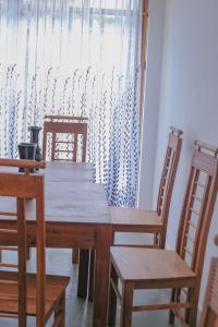 a dining room table with two chairs and a window at Nela House in Galle