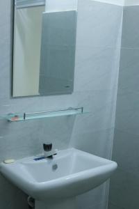 a white sink in a bathroom with a mirror at Nela House in Galle