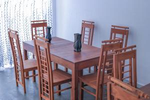 a wooden table and chairs with vases on it at Nela House in Galle