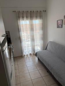 a living room with a couch and a window at Thea Studios in Pyrgadikia