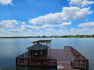 a wooden dock with a gazebo on a lake at BAVARO HOTEL and SPA in Oral