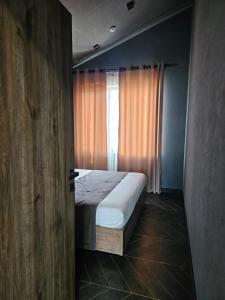 a bedroom with a bed and a window at BAVARO HOTEL and SPA in Oral