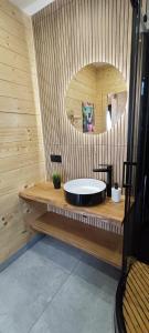 a bathroom with a black tub in a wooden wall at Mazurska Puszcza domek pod klonem z balią ogrodową in Budy +34 photos