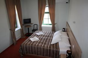 a hotel room with a bed with two dishes on it at Hotel Vinohrad in Milotice