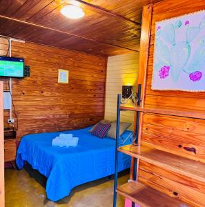 a bedroom with a bed in a wooden cabin at Hostal del Suri in Cafayate