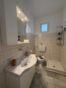 a white bathroom with a sink and a toilet at Thea Studios in Pyrgadikia +70 photos