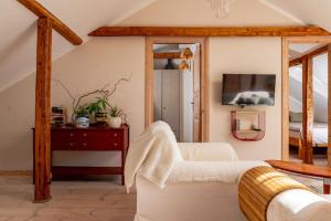a living room with a white couch and a tv at Hygge Home - Bright Cottage-Style Apartment with Terrace & Free Weekend parking in Tartu