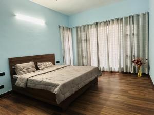 a bedroom with a bed and a large window at Comfy Corner in Chandīgarh