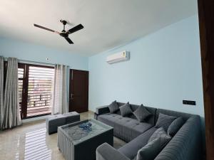 a living room with a couch and a ceiling fan at Comfy Corner in Chandīgarh