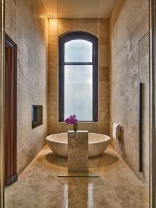 a bathroom with a large tub and a window at Mandarin Oriental Conservatorium, Amsterdam in Amsterdam