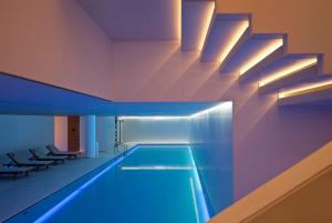 a swimming pool with blue lighting in a building at Mandarin Oriental Conservatorium, Amsterdam in Amsterdam