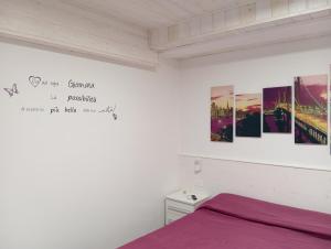 a bedroom with a bed and pictures on the wall at Villa Maldera-case vacanza-loft- loft queen specchio in Trani